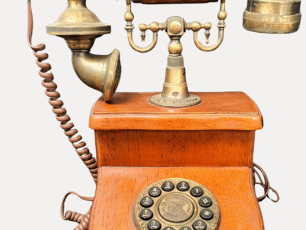 Gros plan sur le cadran du téléphone vintage en bois et métal, un modèle élégant des années 1920.